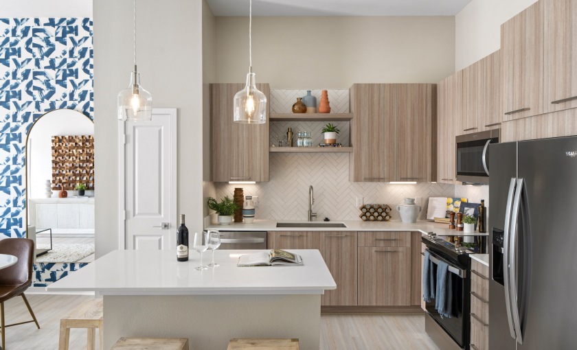 Apartment kitchen island and stainless steel appliances at Aventon Lana